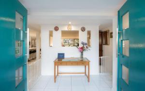 a kitchen with a table and a refrigerator at Torquay Terrace Bed & Breakfast in Hervey Bay