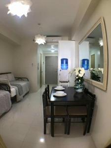 a room with a table and a bed and a mirror at AMS Staycation at Wind Residences in Tagaytay