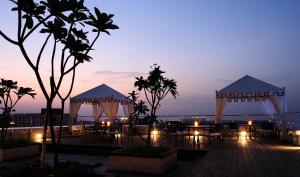 a patio with tables and gazebos at night at Taj Club House in Chennai