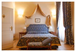 a bedroom with a bed with a blue bedspread at Palazzo Guiderocchi in Ascoli Piceno