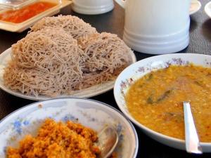 uma mesa com pratos de comida e tigelas de massa em Mountain nest em Ella