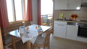 a kitchen with a wooden table and a kitchen with a table and chairs at Sohlerhof in Eichenberg