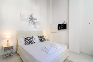 ローマにあるWhite Terrace Ostiliaの白いベッドルーム(ベッド1台、ナイトスタンド付)