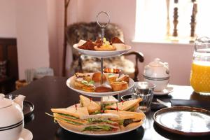 a three tiered tray of sandwiches and pastries on a table at Kasteel Aldenghoor in Haelen