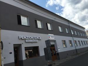 a gray and white building with a sign on it at Penzion DMZ in Ostrava