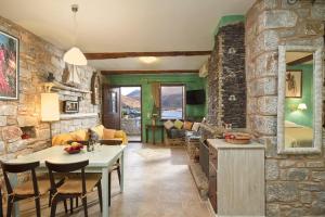 Elixirion Guest House في كارافوستشين: مطبخ وغرفة معيشة بجدار حجري