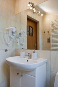 a bathroom with a white sink and a mirror at Apartament City Center Sky in Krynica Zdrój