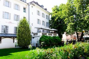 - un bâtiment blanc avec un balcon dans une cour dans l'établissement Apparthotel Privilodges Le Royal, à Annecy