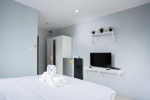 a white room with a bed and a tv at Twentynine KV Apartel in Nonthaburi