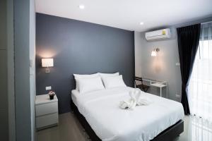 a bedroom with a large white bed with a bow on it at Twentynine KV Apartel in Nonthaburi