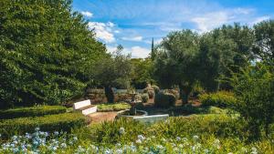 a garden with a fountain and trees and flowers at Hotel Boutique Molino del Arco in Ronda