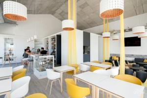 オリフエラ・コスタにあるAppartement Orihuela Costa, Cabo Roigの黄色と白の椅子とテーブルが備わるレストラン