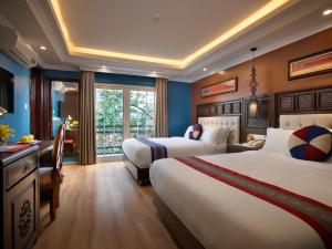 a hotel room with two beds and a window at Eden Boutique Hotel & Spa in Sapa