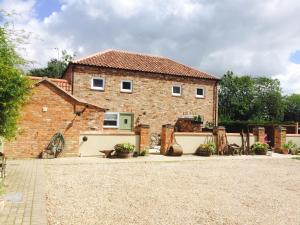 a brick house with a courtyard in front of it at Jockhedge Holiday Cottages in Skegness
