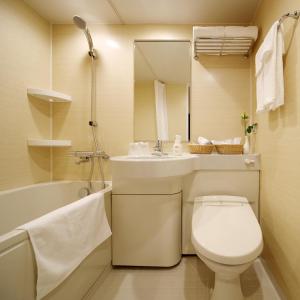 a bathroom with a toilet and a sink and a tub at Red Roof Inn & Suites Osaka Namba Nipponbashi in Osaka