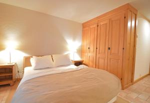 a bedroom with a large white bed with two lamps at Studio Grands Ducs 222 in Verbier