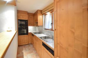 a kitchen with wooden cabinets and a sink at Studio Grands Ducs 222 in Verbier