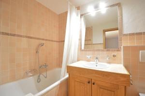 a bathroom with a sink and a tub and a mirror at Studio Grands Ducs 222 in Verbier +10 photos