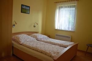 Bett in einem Schlafzimmer mit Fenster in der Unterkunft Ferienwohnanlage Jan in Neuendorf