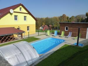 un patio trasero con piscina y una casa en Chata Jílové en Jílové