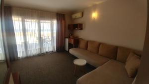 uma sala de estar com um sofá e uma janela em Family Hotel Muses em Sozopol