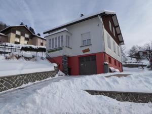 una casa está cubierta de nieve con una entrada en La Petite Bresse, en La Bresse