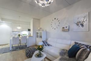 a living room with a white couch and a kitchen at Vasko Luxurious Suites, Nilo in Rovaniemi