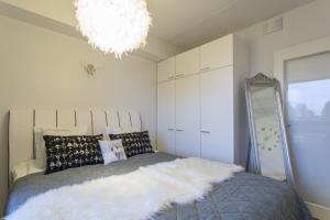 - une chambre avec un lit, un miroir et un lustre dans l'établissement Tuomas' Luxurious Suites, Nilo, à Rovaniemi