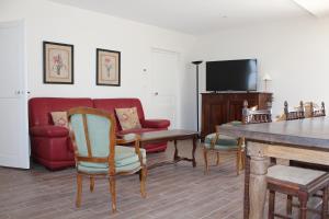 a living room with a red couch and chairs at Gîte Domaine St Georges in Bagneux
