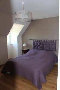 a bedroom with a large bed with a purple bedspread at Gîte Domaine St Georges in Bagneux