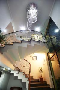 a spiral staircase with a chandelier in a building at Hotel Harmony in Kutaisi