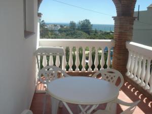 a white table and two chairs on a balcony at Apartamentos Bolonia Paraiso in Bolonia