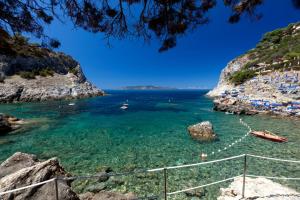 a view of a beach with boats in the water at Boutique Hotel Torre Di Cala Piccola in Porto Santo Stefano