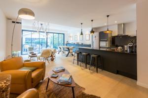 a living room and kitchen with a couch and a table at La Maison Odeia Bordeaux Centre in Bordeaux