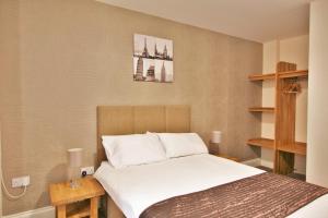 Tempat tidur dalam kamar di Central Studios Gloucester Place by Roomsbooked