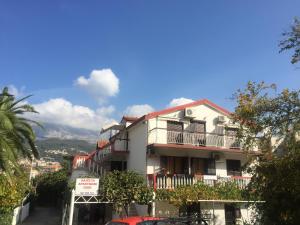a white building with a balcony on a street at Guest House Bajceta in Herceg-Novi