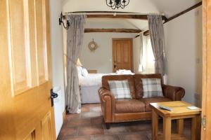 a living room with a couch and a bed at Oak Barn in Wigginton