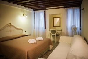 ヴェネツィアにあるカ ヴェーネレ アパートメンツ カンナレージョのベッド2台と机があるホテルの部屋 +19枚の写真