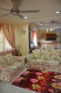 a living room with two couches and a rug at Homestay Mamasya Melaka in Melaka