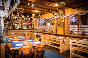 ein Restaurant mit Holztischen und -stühlen und einer Bar in der Unterkunft Edelweiss Carpathians Migovo in Myhowe