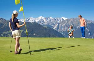 two people playing a game of golf on a golf course at Studio Grands Ducs 222 in Verbier
