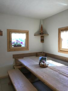 ヴァルフルヴァにあるAgriturismo Malga Dell'Alpeの木製テーブルと窓2つが備わる客室です。