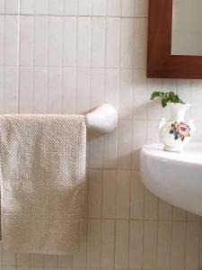 a bathroom with a towel and a vase on a sink at Casa Del Caminero En Tejeda in Tejeda