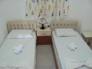 2 camas en una habitación con sábanas blancas en Sea Breeze Apartment Bougainville Bay, en Sarandë