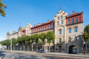 een groot bakstenen gebouw met een auto ervoor geparkeerd bij Rotermann City Apartments in Tallinn