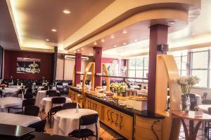 a dining room with tables and chairs and a buffet at Hotel Solaris in São Miguel dʼOeste