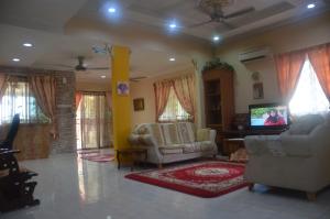 a living room with two couches and a tv at Homestay Mamasya Melaka in Melaka