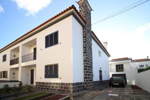 a white house with a car parked in front of it at pdl house garden in Ponta Delgada