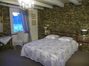 - une chambre avec un lit et un mur en briques dans l'établissement Chambres d'hôtes du Perray, à Candé