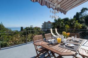 a dining table on the balcony of a house at Apartment Sebalj in Opatija